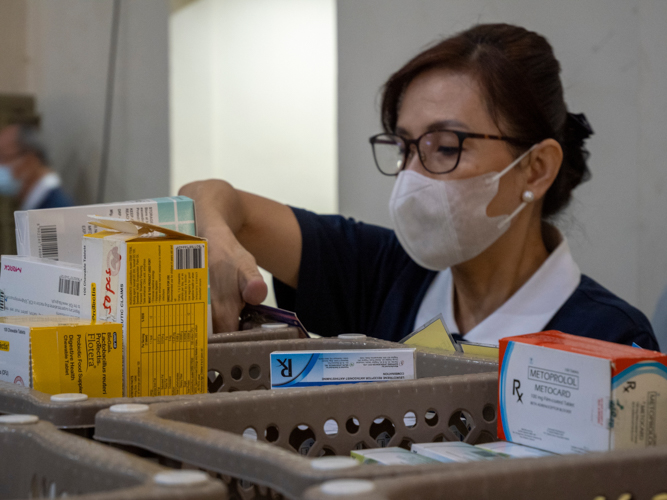 Medicines are properly stored and checked by a Tzu Chi volunteer.