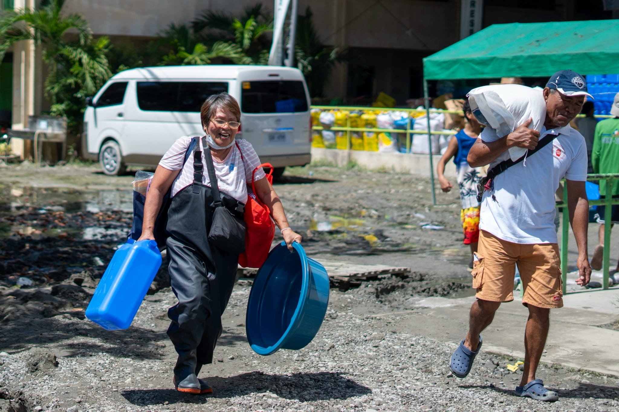 Beneficiary Vilma Castro eagerly carries her relief items back to their assigned evacuation center. She is also excited to share with others about the generous benefactor of these items. 