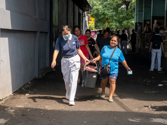 A Tzu Chi Volunteer assists a beneficiary in carrying the relief goods.