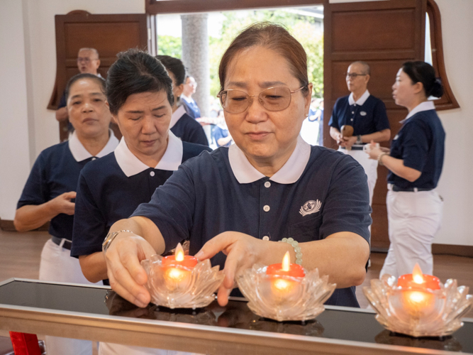 Tzu Chi volunteers and guests place their candle offerings before the Buddhist altar in the Jing Si Abode.