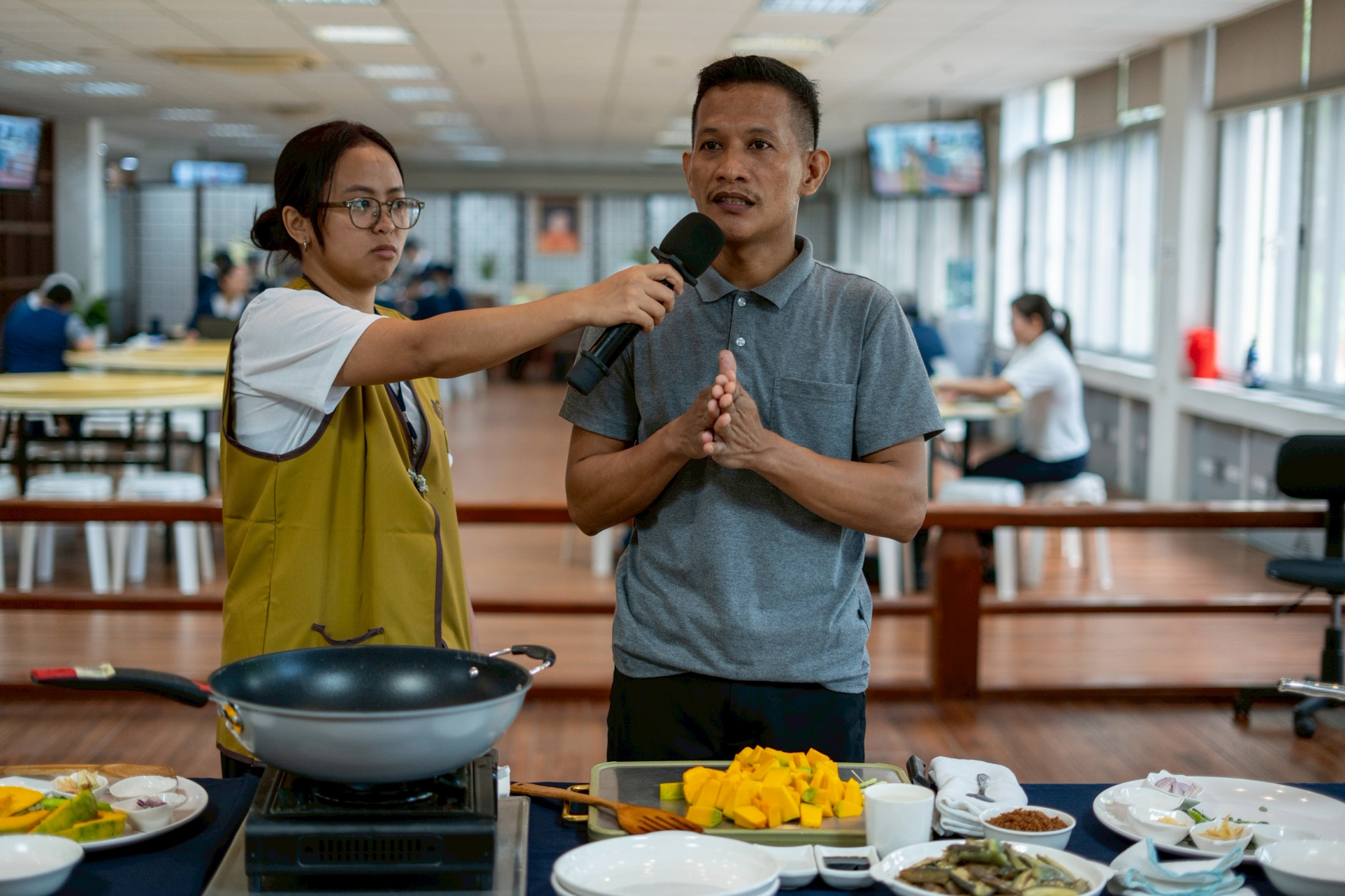 Tzu Chi kitchen staffer Jhay-Ar Ilo (right) teaches scholars how to cook ginataang kalabasa (squash in coconut milk), eggplant with plant-based giniling (ground textured vegetable protein), and a salad of green mango, singkamas (jicama), and tomato.