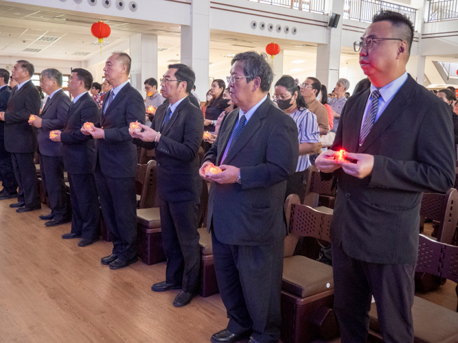 Participants raise a lighted candle as they pray for better things ahead.  