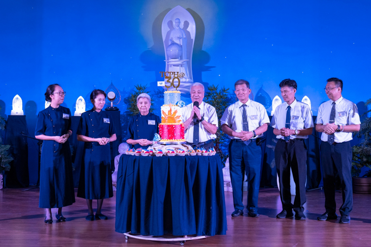 Tzu Chi Philippines CEO Henry Yuñez shares a message to Tzu Chi Philippines alongside his predecessors and deputies with a three-layer PH flag-inspired cake in front. “Let's continue to strive harder and carry on the torch for the next 30 years.”