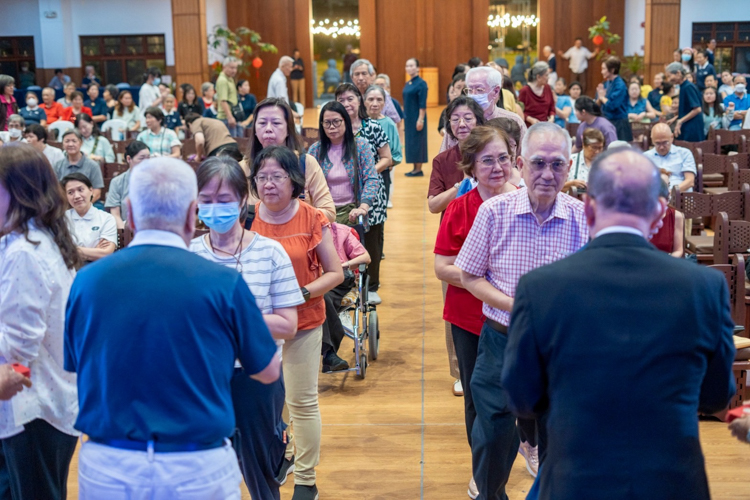 Guests receive angpao, a red envelope containing commemorative coins from Dharma Master Cheng Yen.