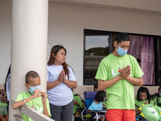 Vivian Alonzo leads residents in joining the Tzu Chi Prayer, symbolizing unity and gratitude.