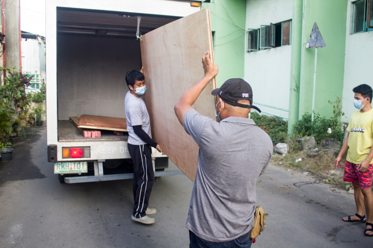 Tzu Chi volunteers unload plywood that will go to repairs of Bahay Mapagmahal. 【Photo by Matt Serrano】