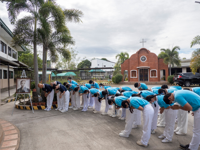 Tzu Chi volunteers and scholars conclude the program with three ceremonial bows, honoring the founder, Dharma Master Cheng Yen.