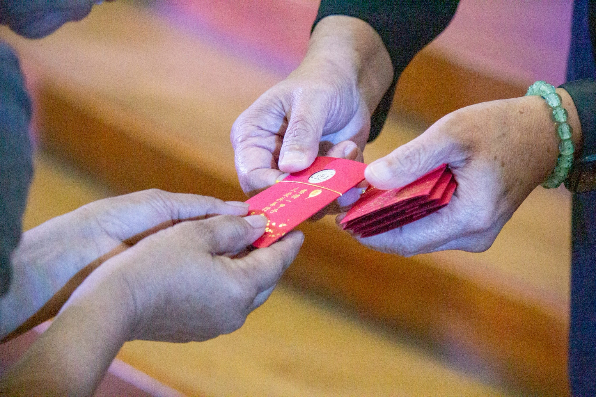 Tzu Chi volunteers distribute angpao to attendees, sharing the heartfelt blessings of Master Cheng Yen.