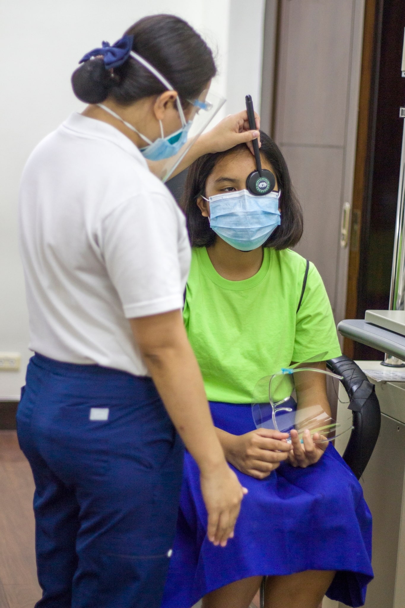 A Tzu Chi volunteer checks the vision of a Girlstown student.【Photo by Matt Serrano】