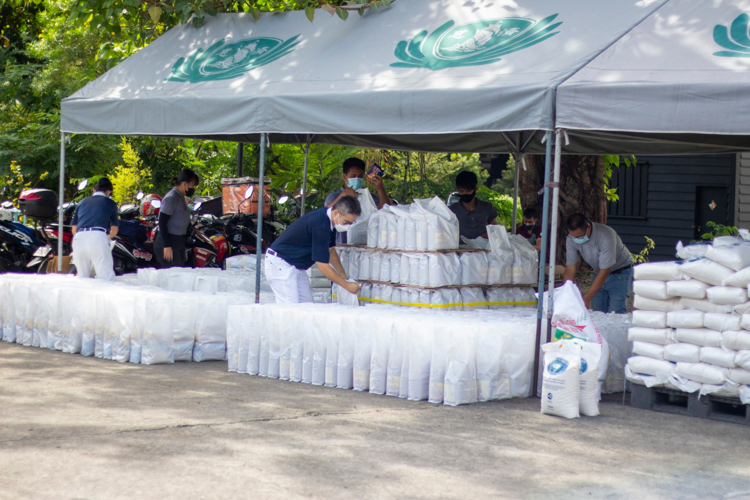 Volunteers prepare the sacks of rice and bags of assorted groceries for scholars to claim after humanities class. 【Photo by Matt Serrano】