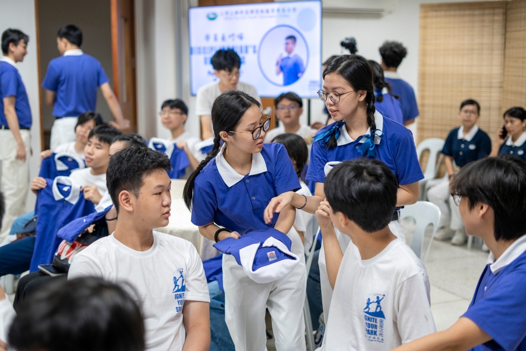 Tzu Chi Youth camp committee members help newly inducted youth with their uniforms. 