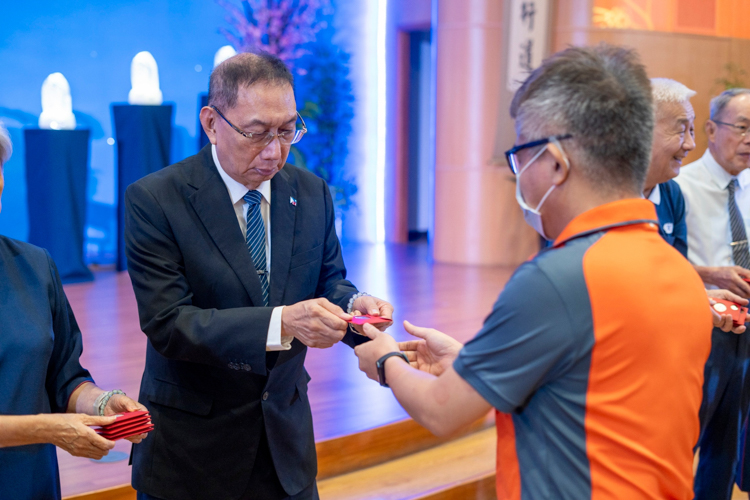 Ambassador Francis Chua joins Tzu Chi volunteers in the distribution of angpao (red envelope) to guests. 