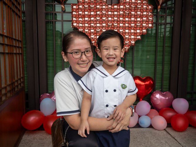 Preschool directress Jane Sy poses for a photo with a nursery student. 