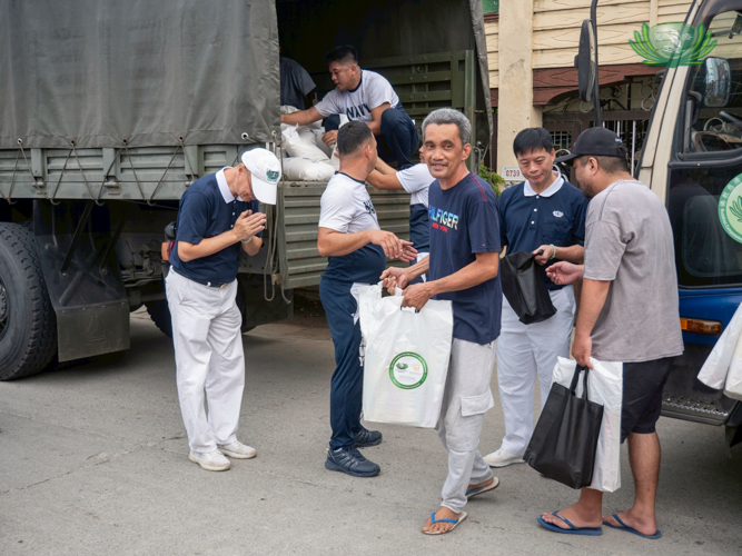 With a smile, a beneficiary receives relief goods.
