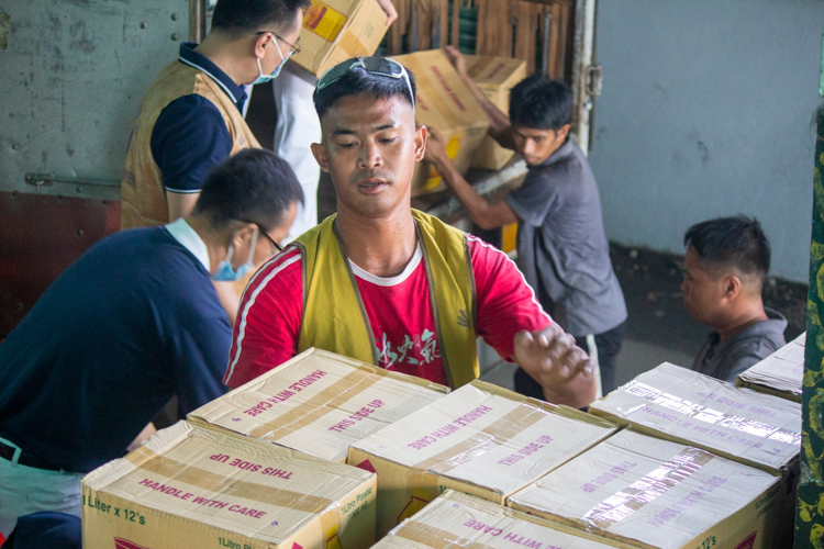 Lewinsky Epon, a beneficiary, volunteers in unloading the relief goods.