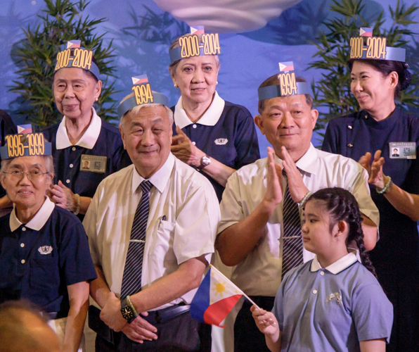 Longtime volunteers, including CEO Yuñez, wear a headdress of the year they started in Tzu Chi Philippines.