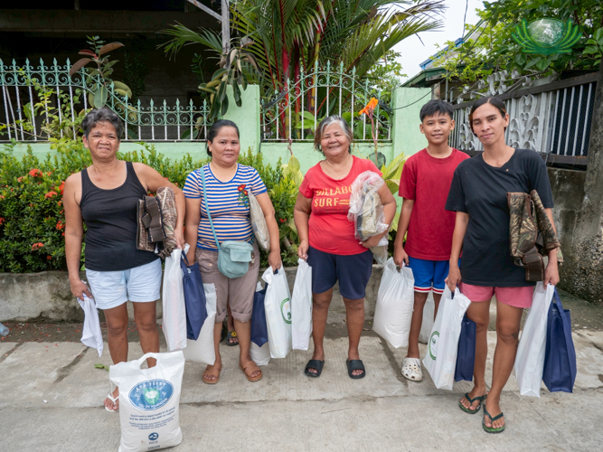 Beneficiaries pose with happy smiles after receiving their relief goods.