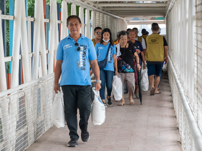 Local government members of Tumana, Marikina gladly help beneficiaries in carrying their relief goods home.