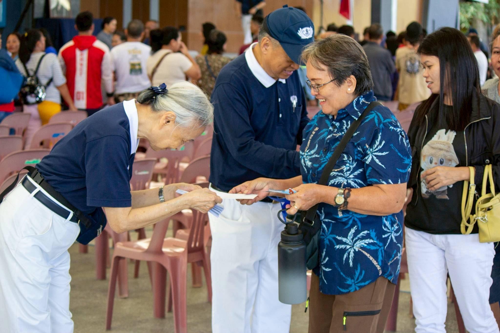 Tzu Chi volunteers distribute grocery gift checks to beneficiaries.