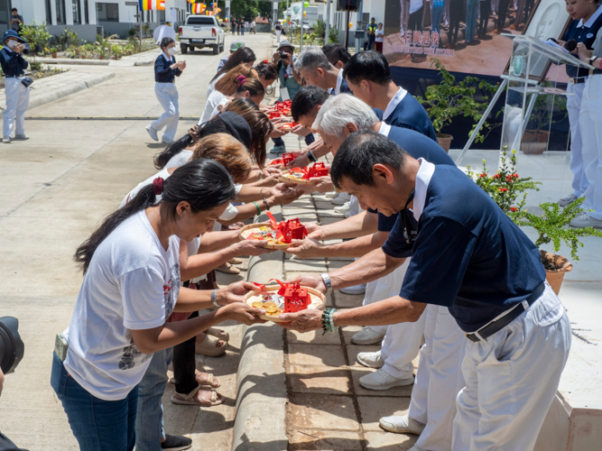 Tzu Chi volunteers present the tokens and house keys to the residents of the Tzu Chi Palo Great Love Village.