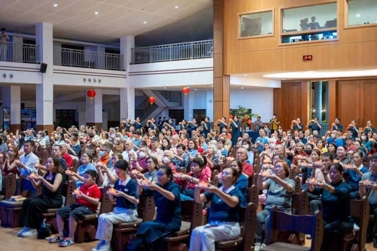 Participants raise their lotus candles in a united prayer for peace and harmony in the world.