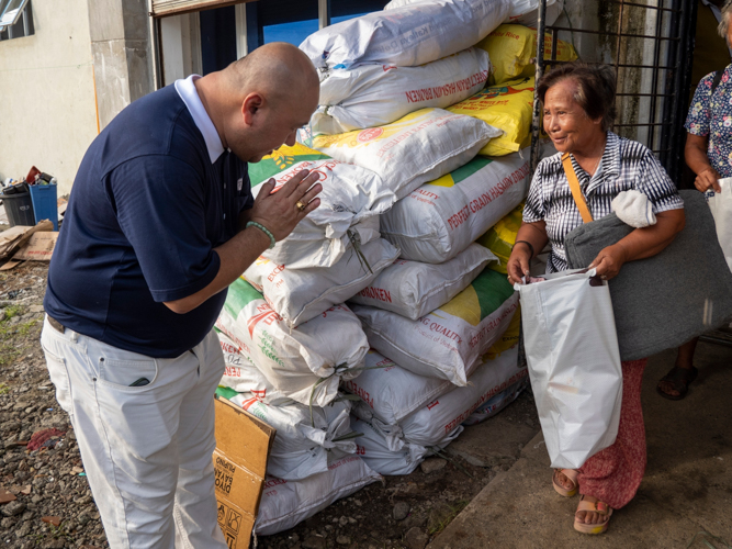 A beneficiary smiles at a Tzu Chi volunteer. 