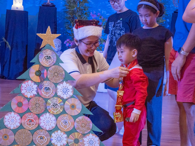 A student wins the Little Mr. Crowd Favorite award for his Christmas Tree, with used CDs as decoration.