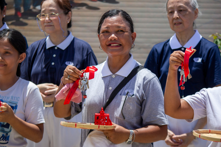 A resident and Tzu Chi volunteer smiles after receiving her house keys.