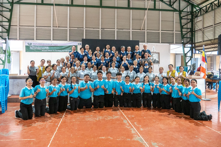 Tzu Chi volunteers, staff, and scholars pose for a photo after the successful relief distribution. 