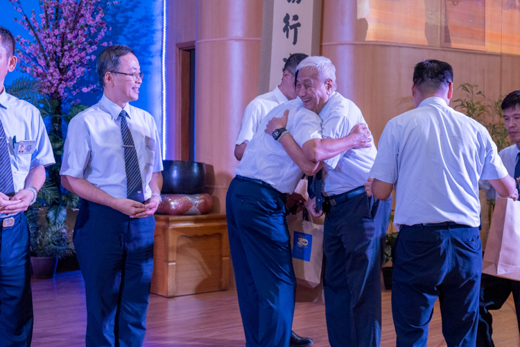 CEO Yuñez hugs a Kaohsiung commissioner as he gives out the anniversary souvenir.