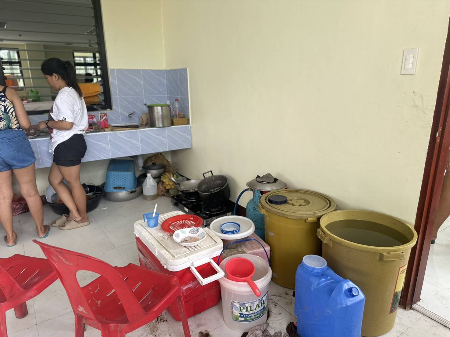 Evacuees store water in the shared kitchen area at the evacuation center.