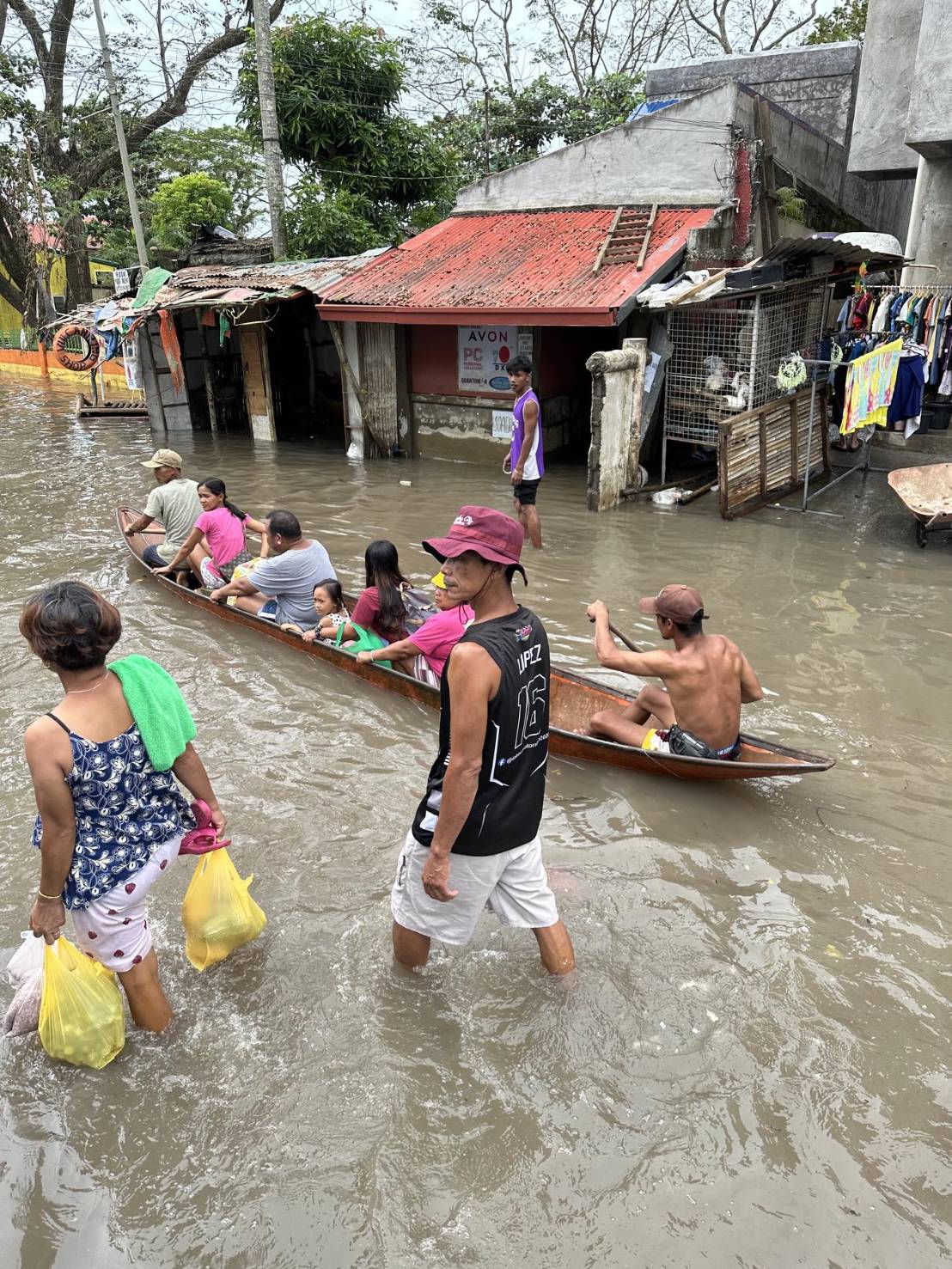 Families use boats to get around due to the continued flooding.