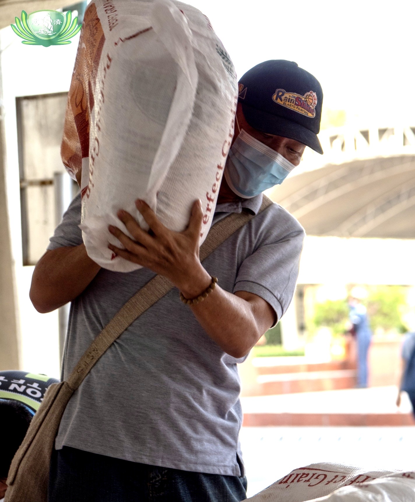 Volunteer Eduardo Yañez assists in unloading a truck of sacks of rice for beneficiaries. 