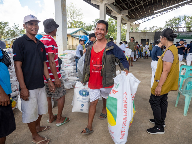 A beneficiary receives 20 kilograms of rice along with blankets, rain boots, clothing, condensed milk, slippers, and sack bags. 