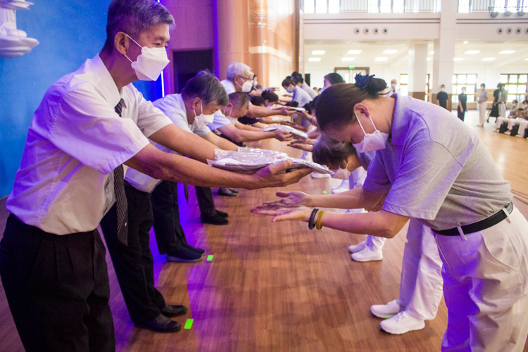 Commissioners (left) present volunteers in training with their uniforms. 【Photo by Matt Serrano】