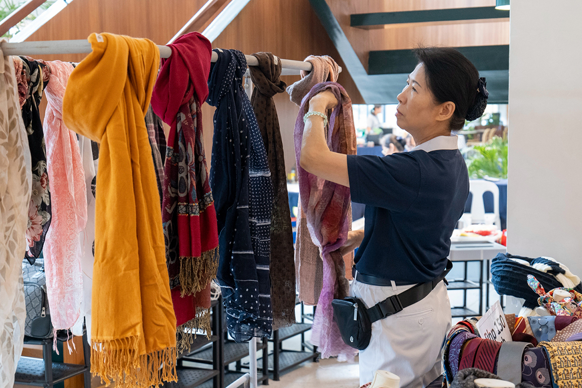 With dedicated service during the two-day event, Tzu Chi Philippines Deputy CEO  Woon Ng thoughtfully prepares and organizes the scarf display.