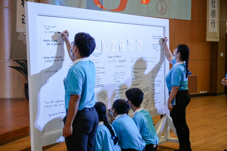 Tzu Chi scholars approach the white board to write the acts of kindness they can commit to. 【Photo by Marella Saldonido】