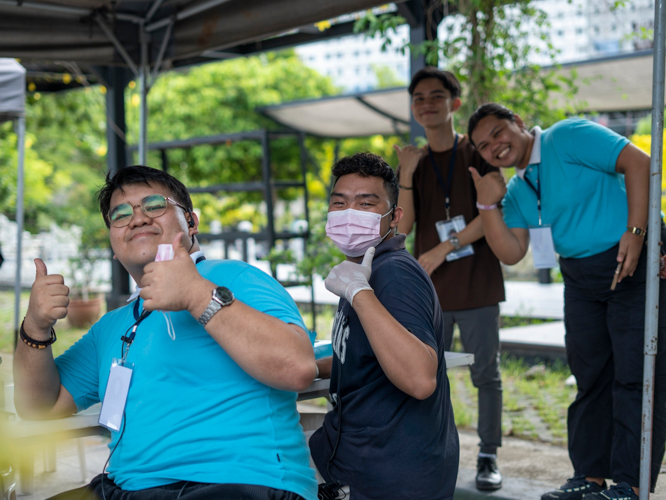 Working committee members enjoy and pose together for a photo while performing their duties at the scholars’ camp.