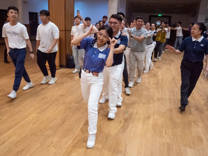 Tzu Chi 2024 Youth Camp Head Kylie Francisco (in Tzu Chi Youth uniform) leads Tzu Chi Youth, volunteers, camp participants, and their families in the spirited song and dance “Pulling the Ox Cart.” 