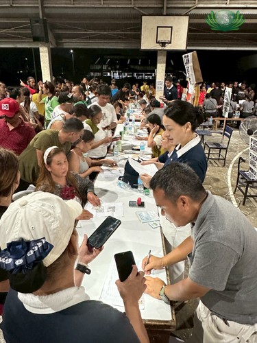 Staff and volunteers manage the busy registration table on Day 1, releasing stubs to organize relief distribution efficiently.