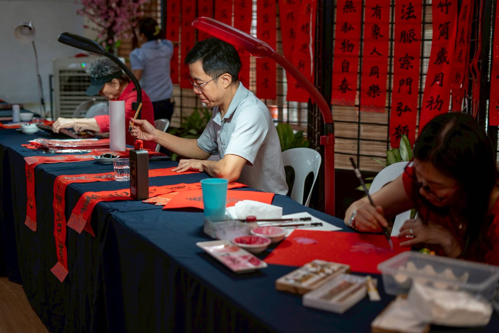 Calligraphers fill red scrolls with affirmations of good health, good fortune, and a virtuous heart and conduct. 