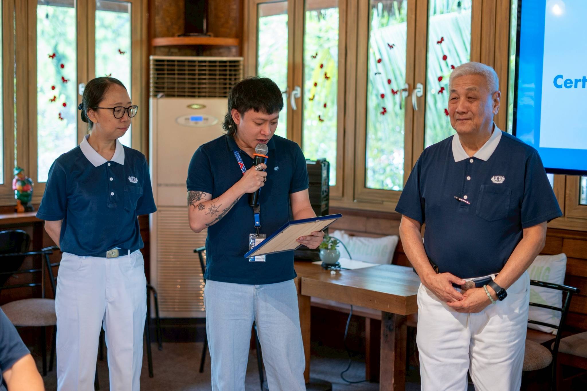 Tzu Chi Deputy CEO Peggy Sy Jiang listens as Unified TVET Program Registration and Accreditation System (UTPRAS) Focal Person Rene Boy Escuban reads the certificate to Tzu Chi Philippines CEO Henry Yuñez. 