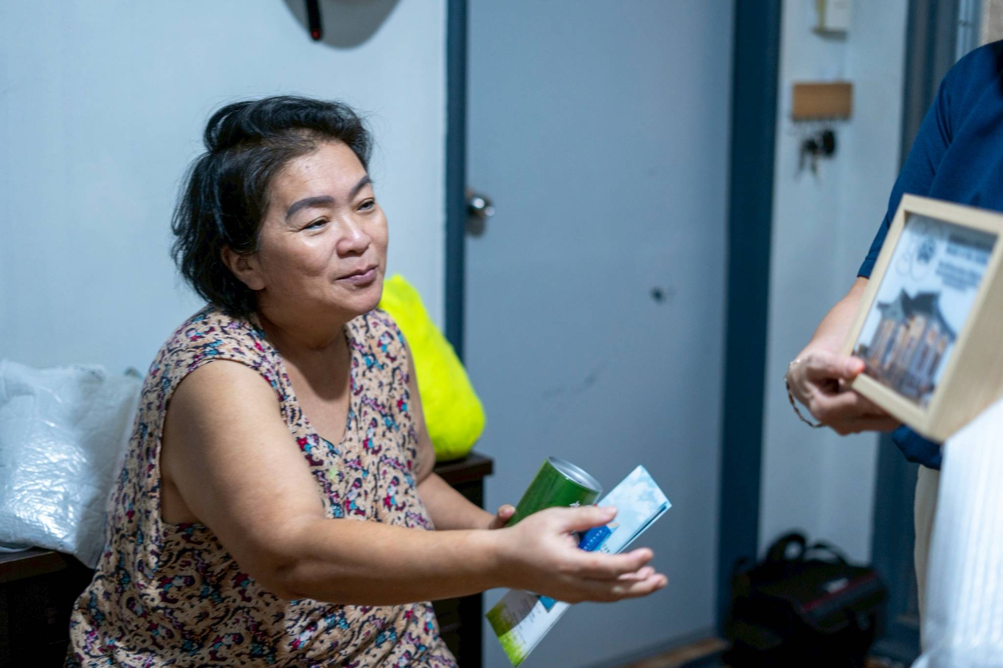 A Tzu Chi volunteer gives medical assistance beneficiary Pilar Ang Si a lighted image of Tzu Chi’s Jing Si Abode, a souvenir from the foundation’s 30th anniversary in the Philippines.