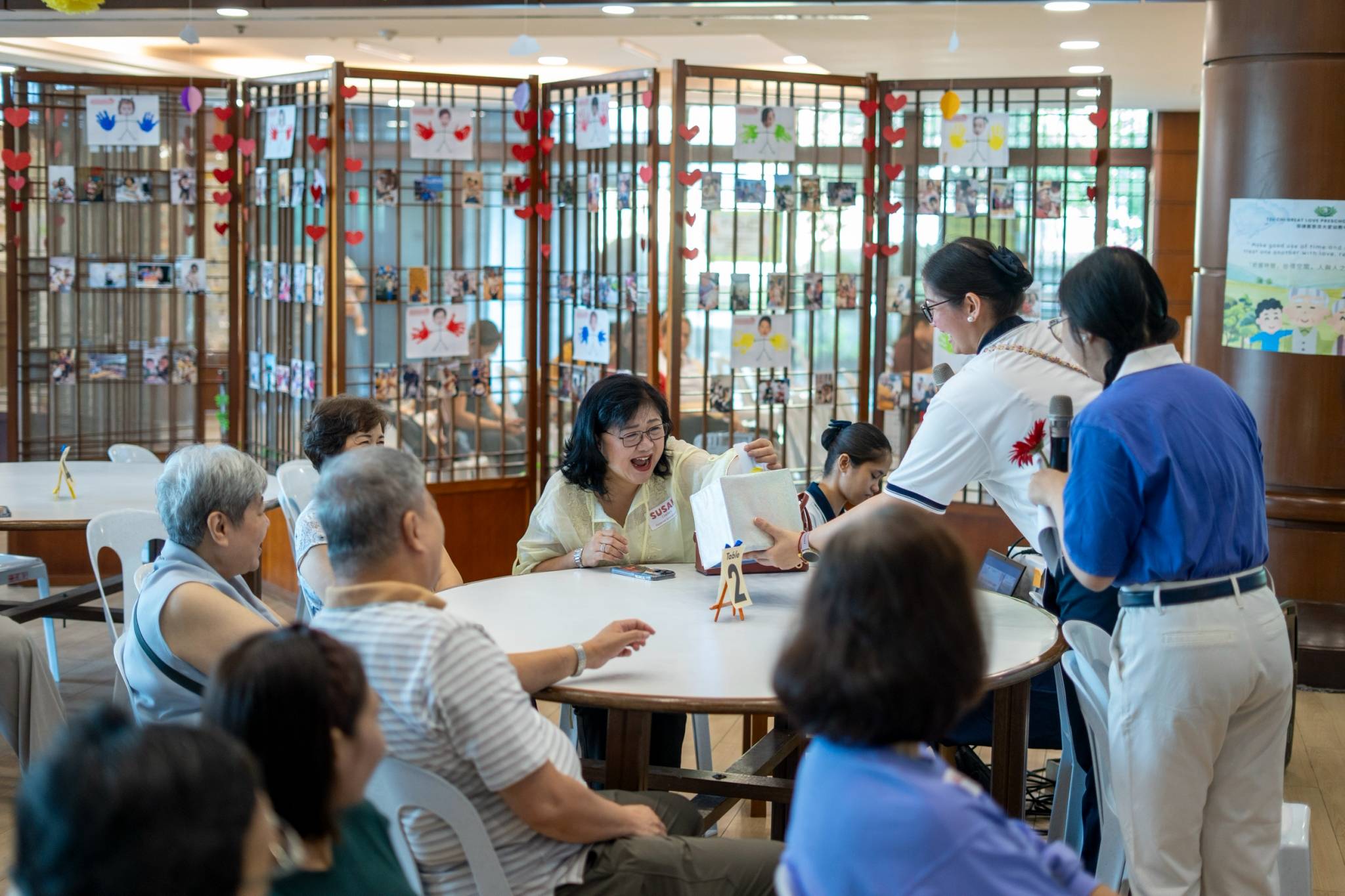 Sharing wisdom and warm memories,  grandparents draw questions from a box during an engaging ice-breaker activity.