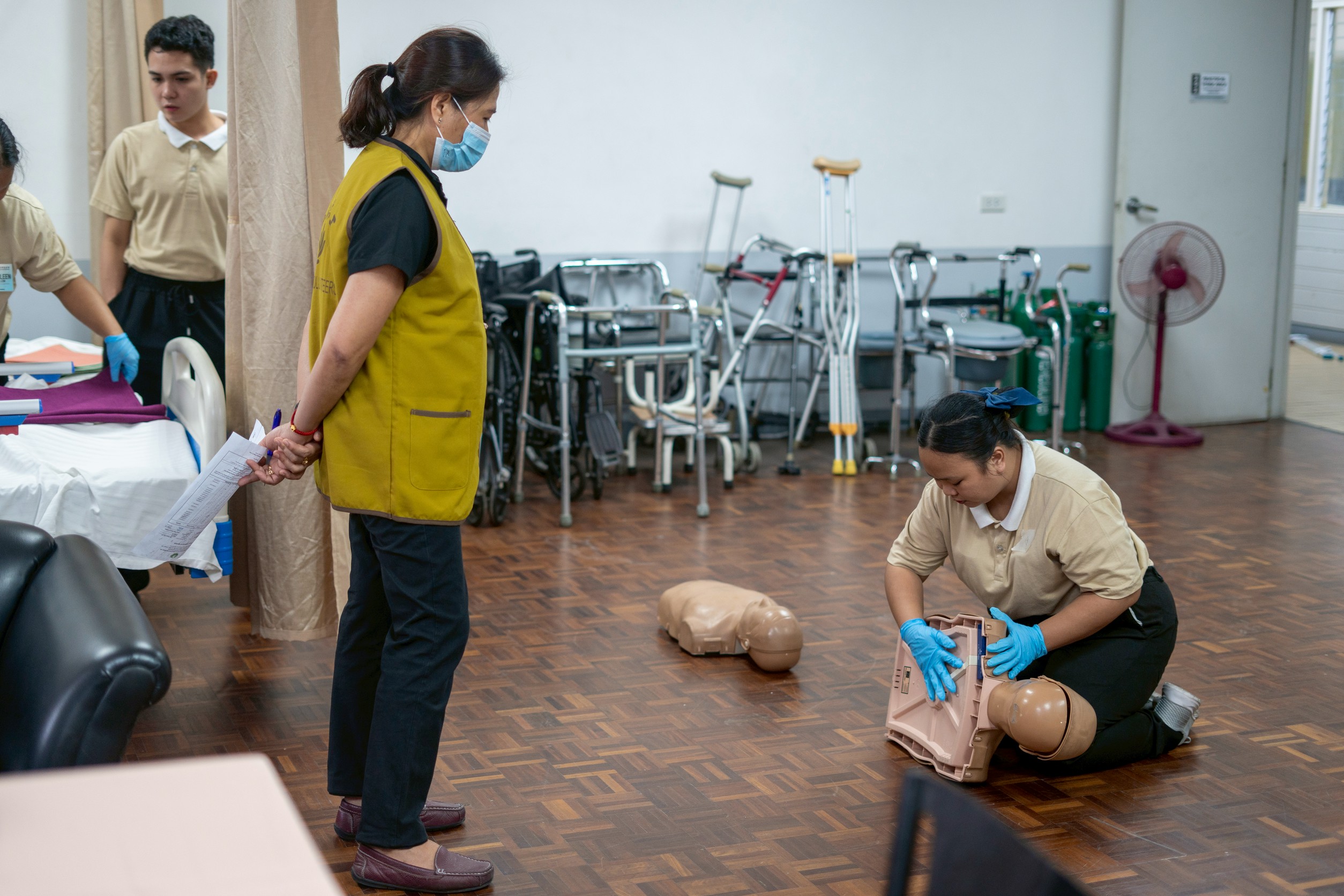 Under the guidance of their caregiving instructor, Ruth Sauz, Gemmalyn demonstrates the proper technique for administering back blows to assist a choking victim.