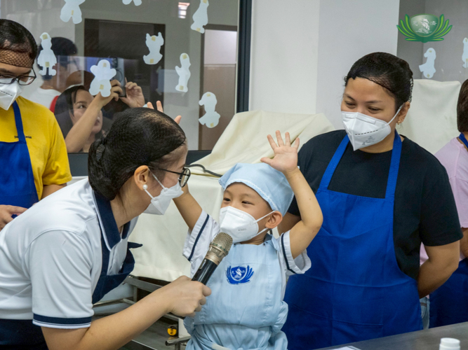 A student happily cheers, ready to showcase his baking skills. 