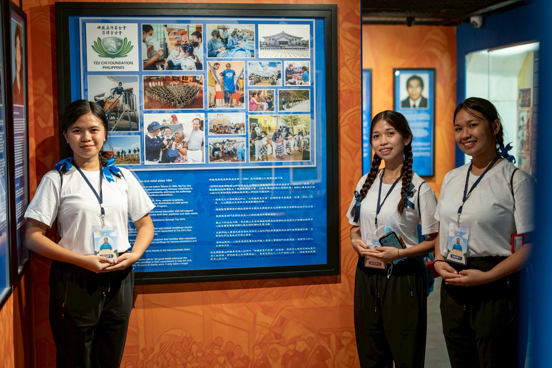 In Bahay Tsinoy, scholars pose next to a display depicting Tzu Chi Foundation’s contributions in disaster relief. 
