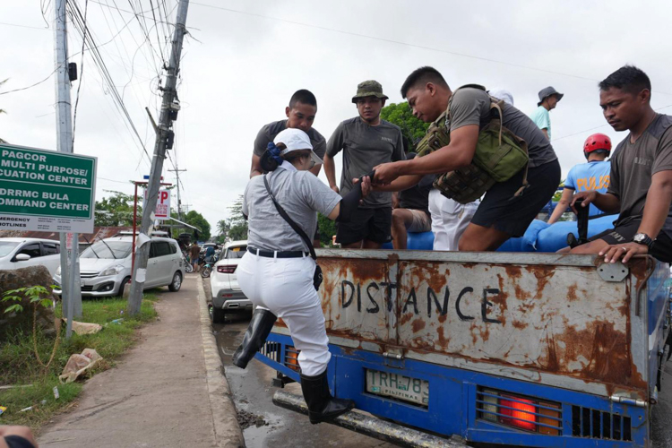 Tzu Chi Bicol volunteers coordinate with MDRRMC Bula Camarines Sur to distribute rice to storm survivors.