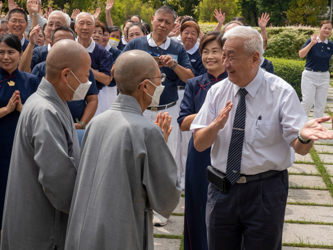 Tzu Chi Philippines CEO Henry Yuñez (right) cheerfully initiated the welcoming of Taiwan guests, including Dharma Masters De Bei (center) and De Pei (left).