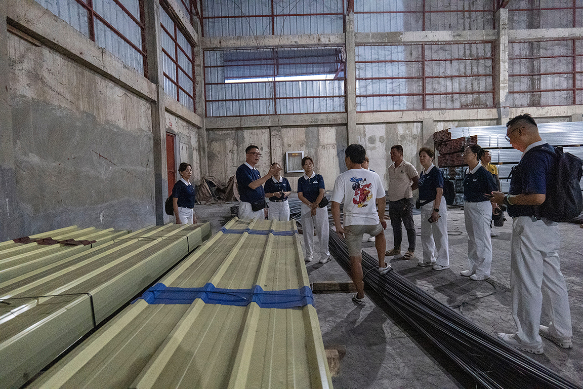 At a supplier of construction materials, volunteers check items like long span color-roof set aside for beneficiaries with totally damaged homes. 